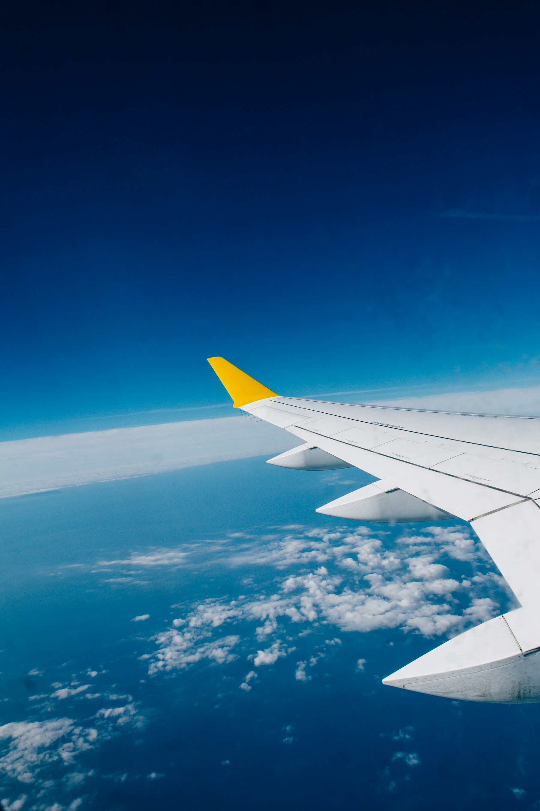 Vista de uma asa de avião sobre as nuvens durante uma viagem internacional